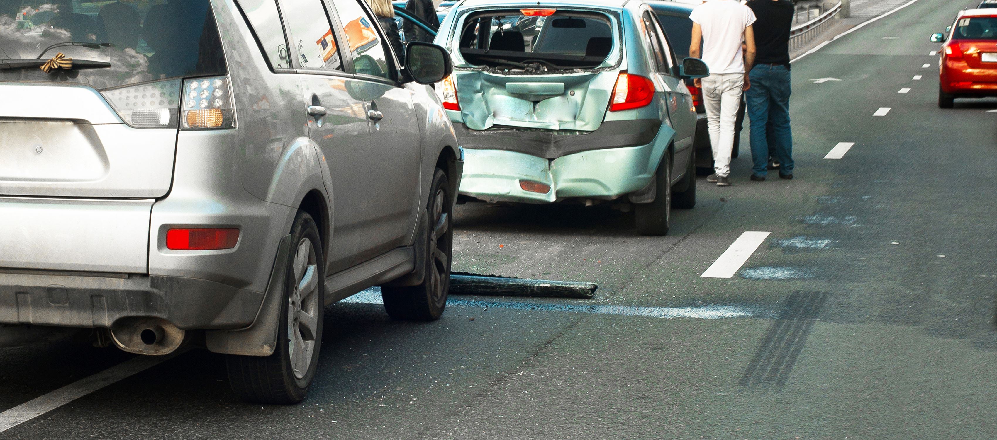 People standing next to a rear-end car accident